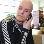 Mark Pollock holding a mobile telephone as he speaks to potential sponsors