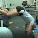 Mark Pollock performing press-ups in a blue tshirt and shorts while his legs are raised over a bar.