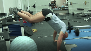 Mark Pollock performing press-ups in a blue tshirt and shorts while his legs are raised over a bar.