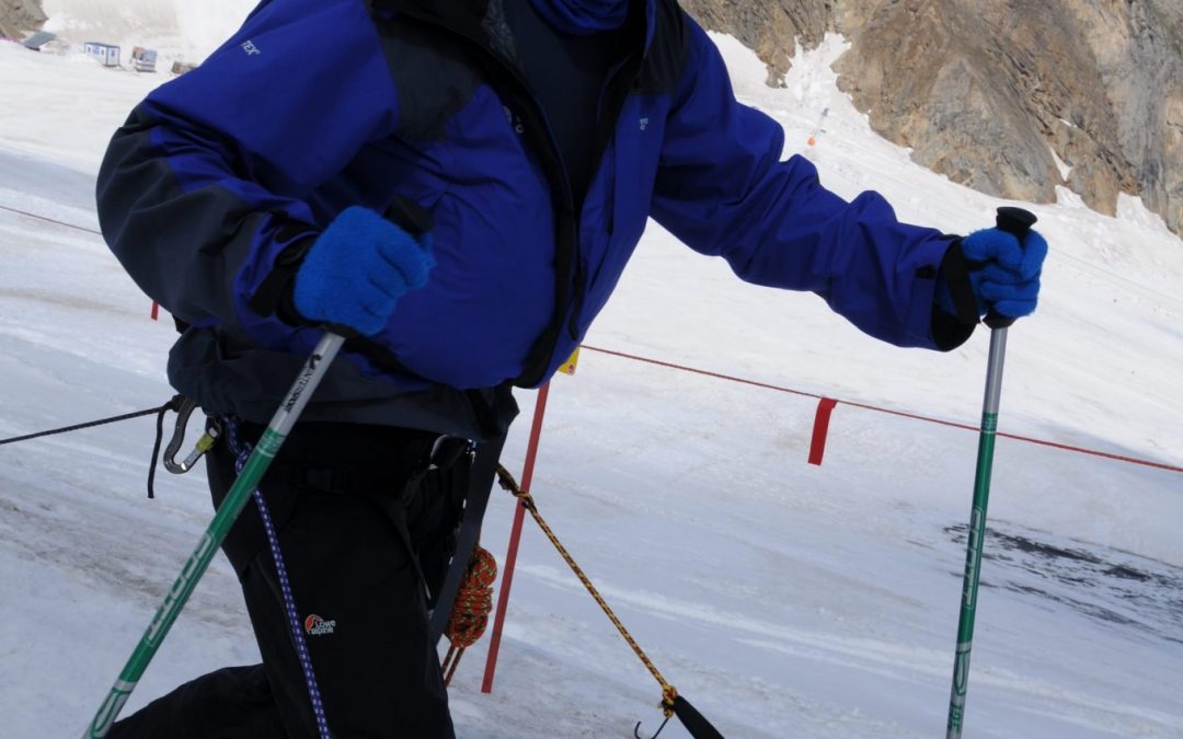 Mark Pollock, dressed in snow gear and dark glasses, skiing in snow