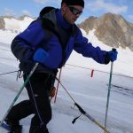 Mark Pollock, dressed in snow gear and dark glasses, skiing in snow