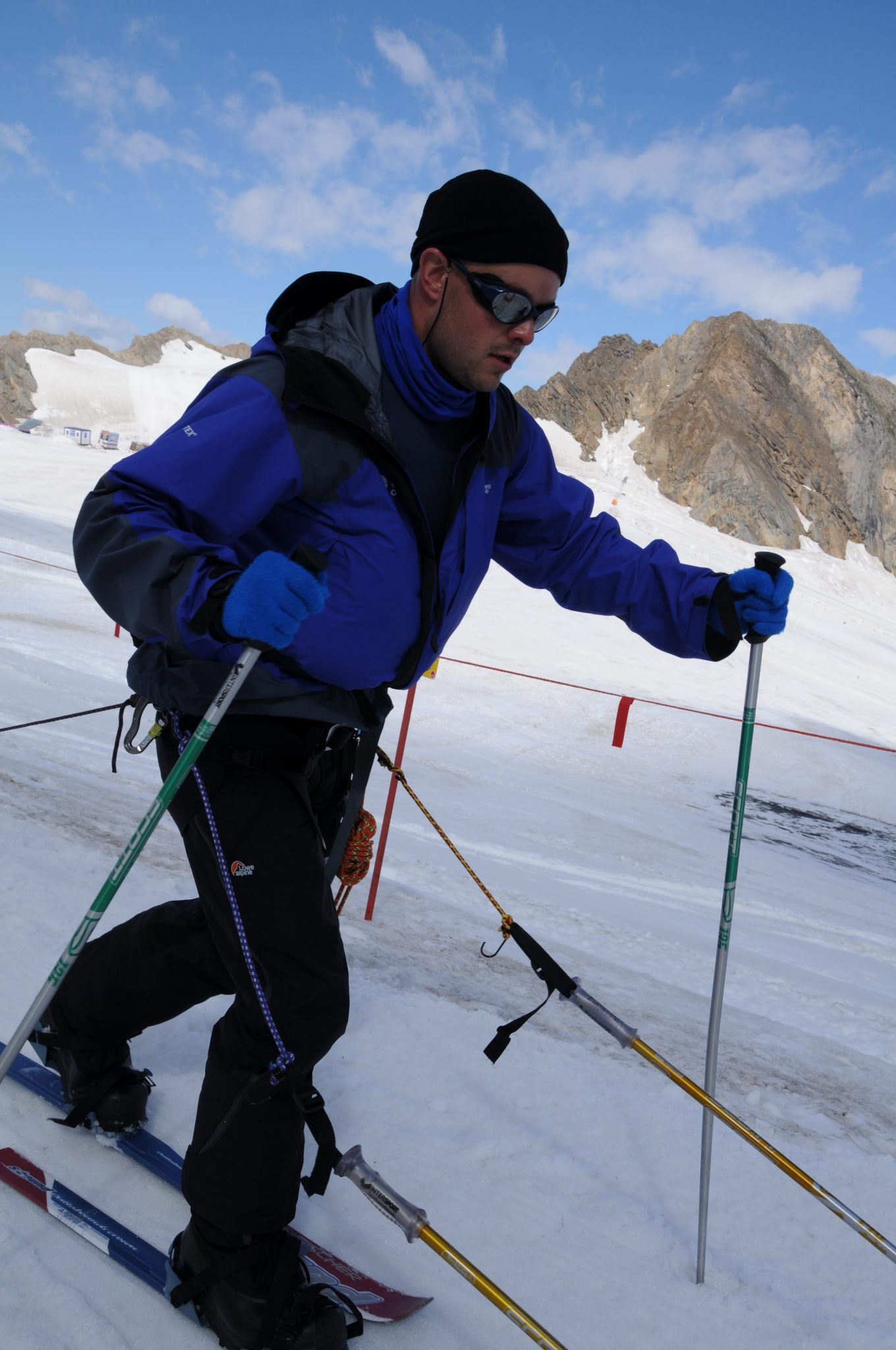 Mark Pollock, dressed in snow gear and dark glasses, skiing in snow