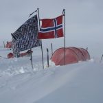 Marks South Pole Flag, which features all the faces of his supporters around the word, is pitched in the snow beside the Norwegian flag in front of a red tent.